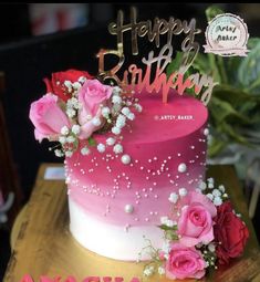 a birthday cake decorated with pink and white flowers