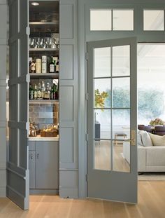 an open door leading to a living room and dining room area with wood flooring