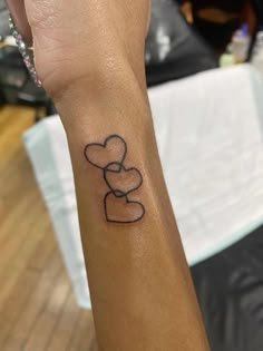 a person's arm with a tattoo on it that has a heart and two hearts in the middle