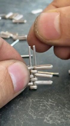 a person is holding several pins in their fingers