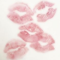 some pink lips are on a white surface