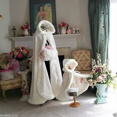 a woman in white fur coat standing next to a mannequin with flowers on it