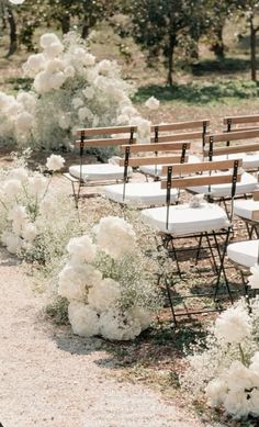 an outdoor ceremony with white flowers and chairs