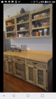 a kitchen island made out of pallet wood with open shelving units above it