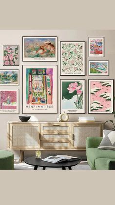 a living room filled with lots of pictures on the wall above a coffee table and green chairs