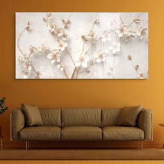 a living room with an orange wall and white flowers on the wall in front of it