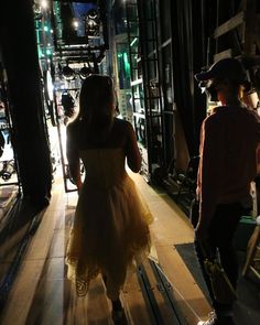 two people are walking down the street at night