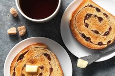 two white plates topped with slices of bread next to a cup of coffee and sugar cubes