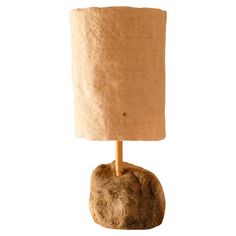 a lamp that is on top of a rock with a wooden stick sticking out of it