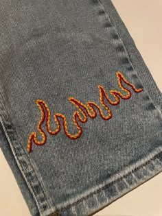 a pair of jeans with embroidered words on them