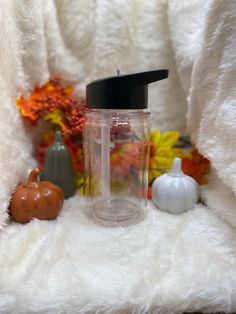 a blender sitting on top of a white blanket next to pumpkins and gourds