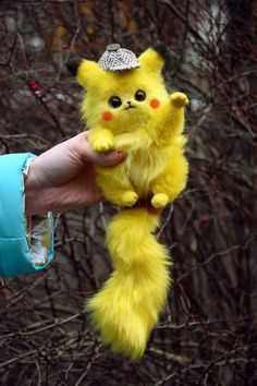 a person holding a yellow stuffed animal in their hand