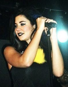 a woman holding a microphone in her right hand