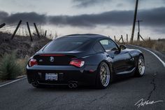 a black sports car driving down the road