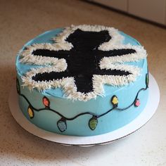 a cake decorated with icing and lights on top of a table