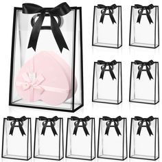 six clear gift bags with black bows and ribbons on each one, all in different sizes