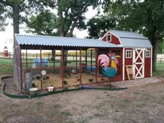 a chicken coop with chickens in it on top of grass and dirt area next to trees