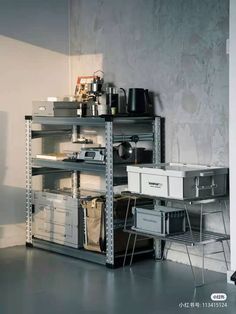 a metal shelving unit with various items on it in a room that appears to be empty