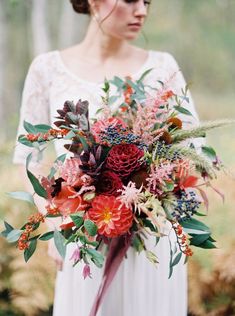 a woman holding a bouquet of flowers in her hands