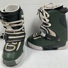 pair of green snowboard boots with white laces