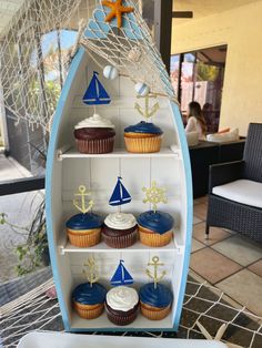 cupcakes are arranged in the shape of a boat and sailboats on display