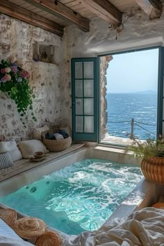 an indoor jacuzzi tub in the middle of a room with a view out onto the ocean