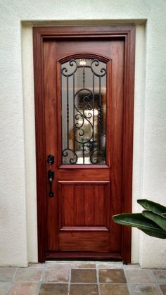 a wooden door with wrought iron grills on it