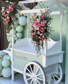 a white cart with flowers and balloons on it