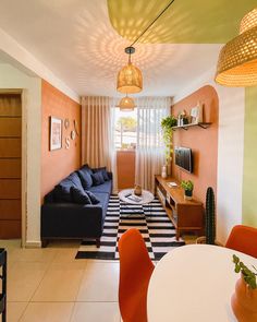 a living room with black and white checkered flooring next to a dining table