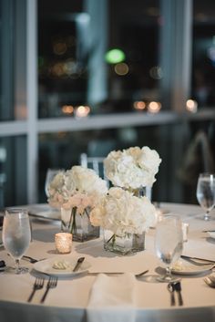 the table is set with white flowers and candles