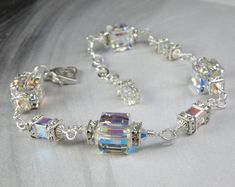 Stunning and sparkly bracelet features Swarovski crystal cubes and rhinestone crowns for an attention getting accessory at your next holiday soiree. Gorgeous Swarovskis are a modern cube design yet looks like an elegantly set traditional diamond bracelet. Perfect gift for ladies born in April since diamond her birthstone. A thoughtful gift for moms of the bride or groom. Modern, streamline and goes with everything in her closet!Bracelet Details:- Bracelet Length is adjustable from 7 to 8 inches Elegant Crystal Embellished Bracelets As Gift, Elegant Crystal Embellished Bracelets For Gift, Silver Crystal Embellished Bracelet For Gift, Sparkling Crystal Bracelet For Anniversary, Elegant Beaded Bracelets With Bling For Wedding, Silver Crystal Embellished Bracelet Gift, Crystal Bracelet Gift, Silver Crystal Bracelet For Gift, Costume Jewelry Style, Elegant Adjustable Crystal Bracelet, Nickel Free