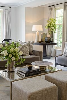 a living room filled with lots of furniture and flowers on top of a coffee table