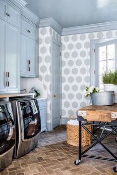 a washer and dryer sitting in a room next to a table with flowers on it