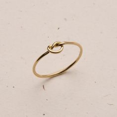 Dainty and delicate, the Love Me Knot Ring is one of the sweetest additions to our stacking kellection. Made to remember the ties to our loved ones, this beauty is the perfect gift for the special someone in your life or to permanently have your nearest and dearest close at hand. Gold Rings Made Of Recycled Gold As A Gift, Gold Recycled Gold Rings For Gifts, Gold Recycled Gold Ring Gift, Gift Gold Ring Made Of Recycled Gold, Dainty Stackable Rings As Gift, Dainty Stackable Rings Gift, Classic Stackable 14k Gold Filled Rings As Gift, Classic 14k Gold Filled Stackable Rings Gift, Classic Midi Rings In Recycled Gold As A Gift