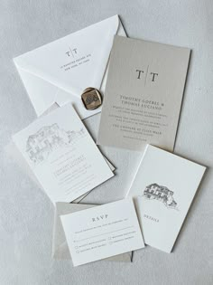 the wedding stationery is laid out on top of each other, including two envelopes and