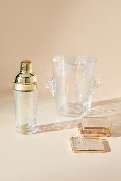 an empty glass and some gold items on a table