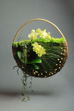 a wicker basket with flowers and greenery in the shape of a flowerpot