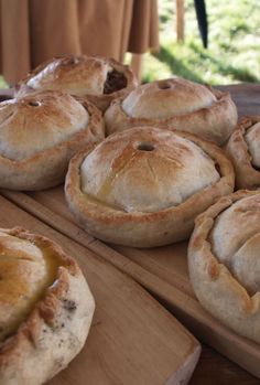 freshly baked pies on wooden cutting boards ready to be served at an outdoor gathering