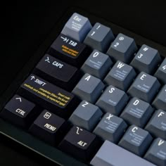 a close up view of a computer keyboard with black keys and yellow letters on it