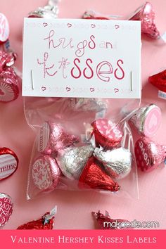 valentine's day candies are wrapped in cellophane and placed on a pink surface