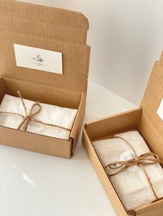 two open boxes with wrapped presents tied in twine and sitting next to each other