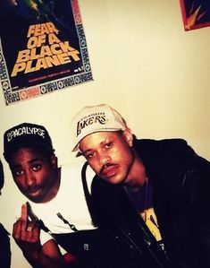 three men are posing for the camera in front of a poster