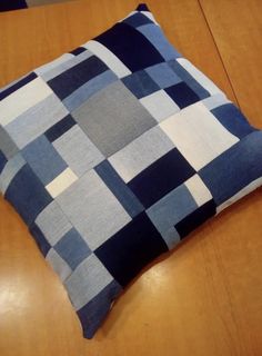 a blue and white pillow sitting on top of a wooden table