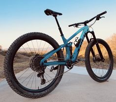 a blue mountain bike parked on the side of a road