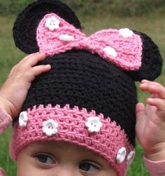 a baby girl wearing a crocheted minnie mouse hat