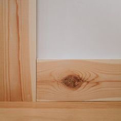 the corner of a wood paneled room with white walls and wooden flooring that has been cut in half