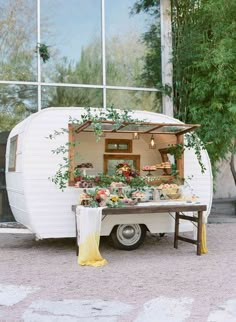 an old camper is decorated with flowers and greenery