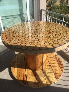 a wooden table sitting on top of a patio next to a glass door and window