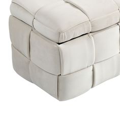 a white leather ottoman sitting on top of a wooden table