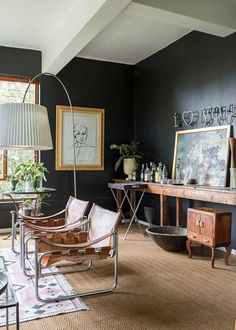 a living room filled with furniture and a large painting on the wall above it's windows